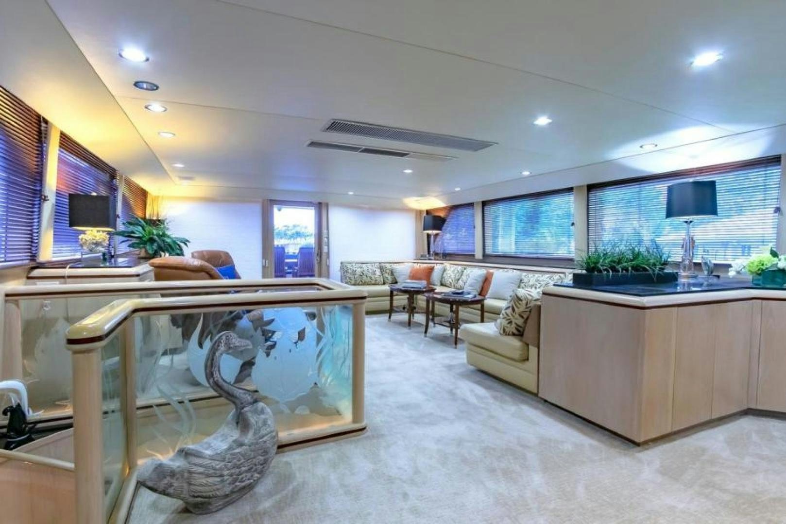 a large living room with a large glass table and a large window aboard K Yacht for Sale
