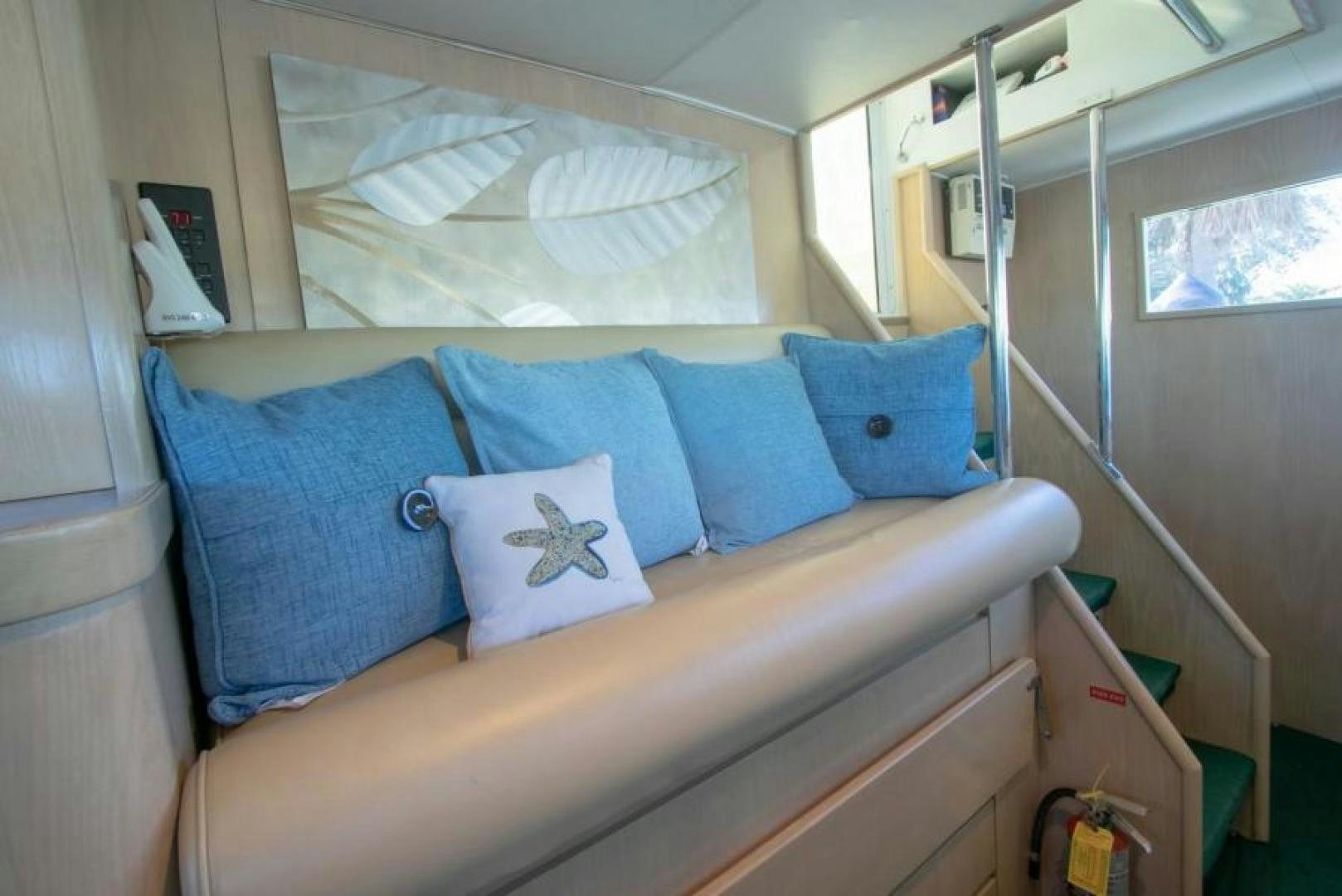 a bed with blue pillows aboard K Yacht for Sale