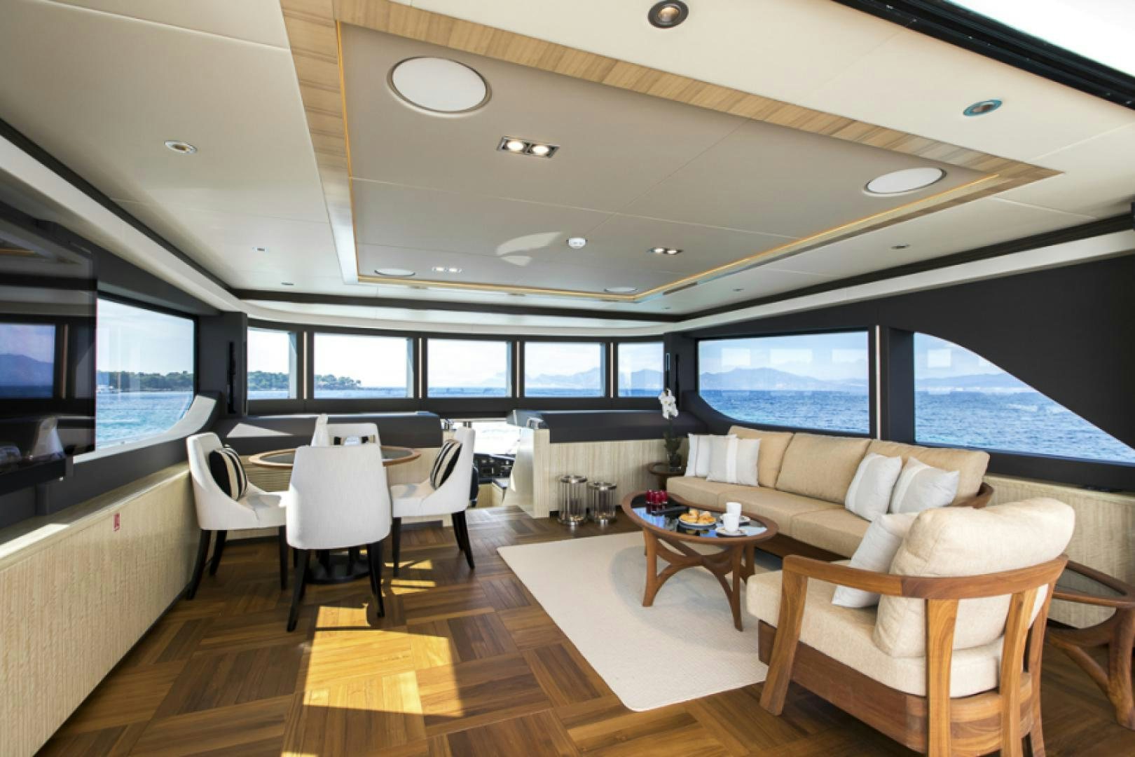 a room with a large window and a table with chairs and a large window aboard KRISHH Yacht for Sale