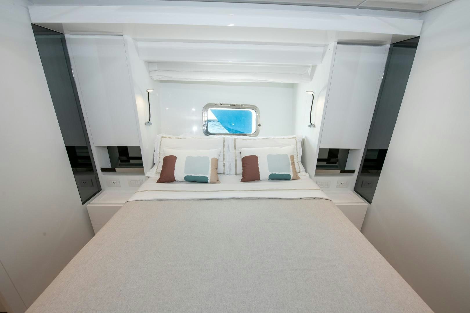 a white room with a bed and a window aboard MARAVI Yacht for Sale