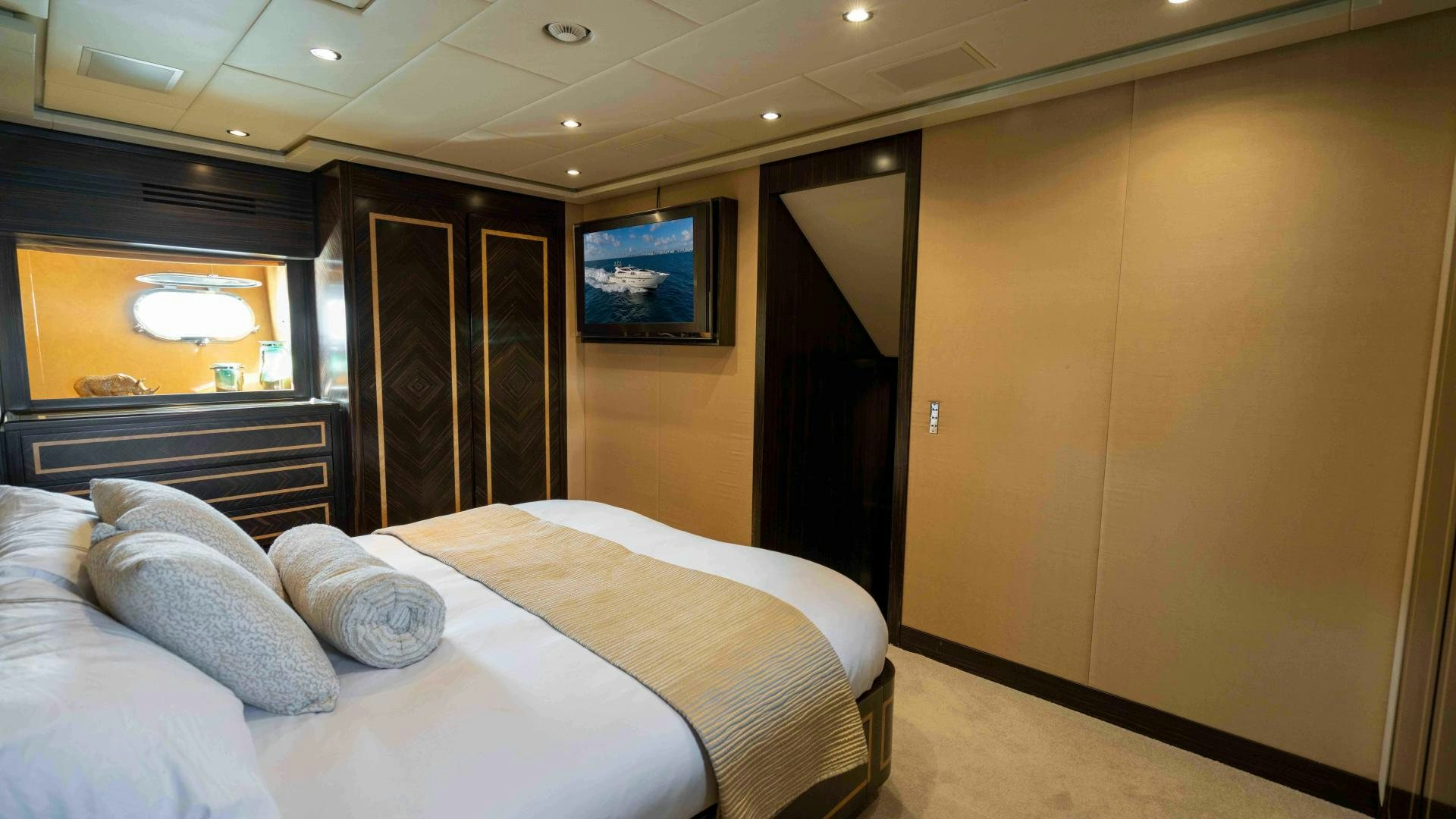a room with a bed and a television aboard ENCORE Yacht for Sale