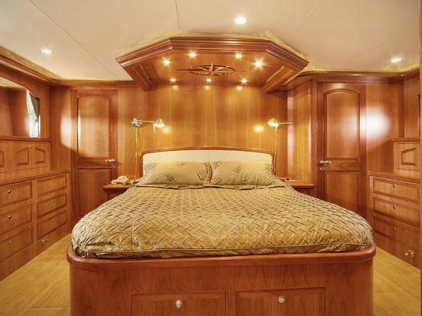 a bed with a wooden headboard aboard FOLIE DEUX Yacht for Sale