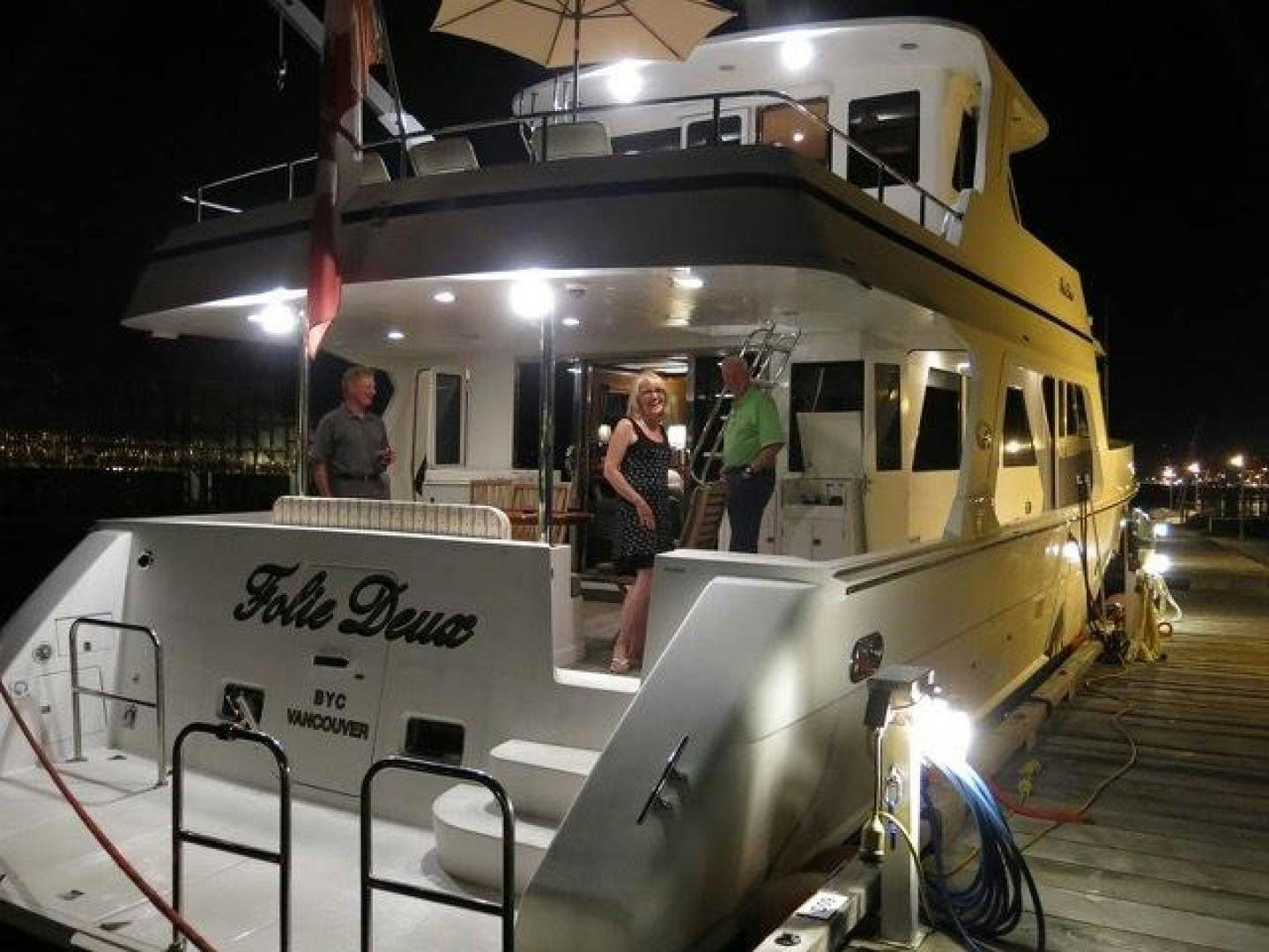 a couple of people standing next to a white vehicle aboard FOLIE DEUX Yacht for Sale