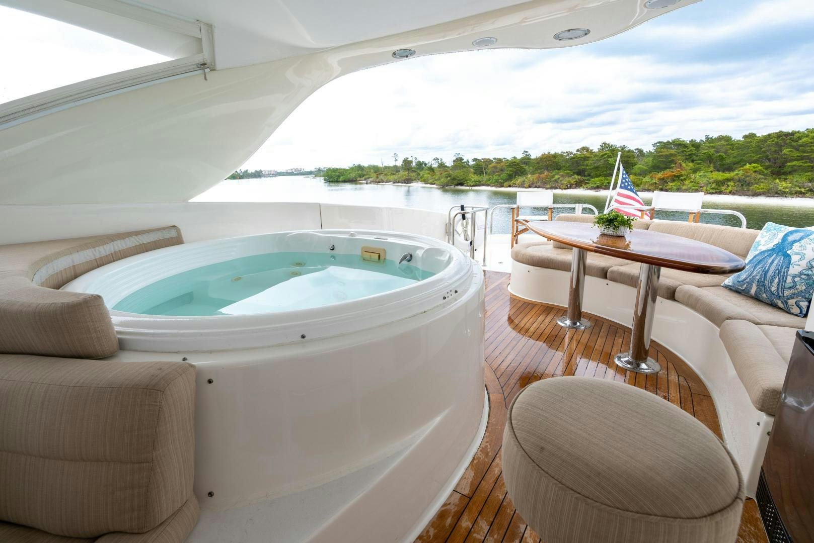 a large white tent with a table and chairs and a view of the water aboard STARFIRE Yacht for Sale