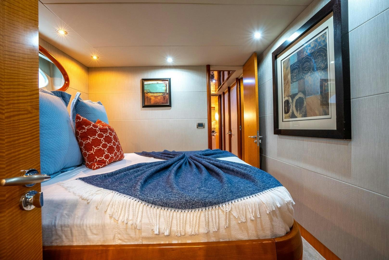 a bed with blue and red pillows aboard STARFIRE Yacht for Sale