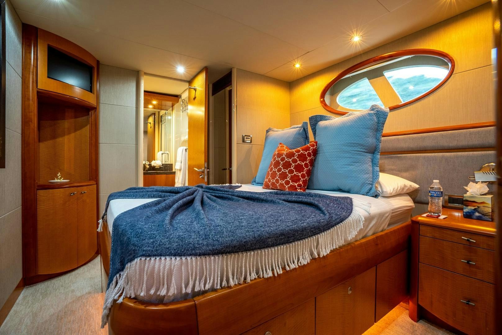 a bed with blue sheets aboard STARFIRE Yacht for Sale