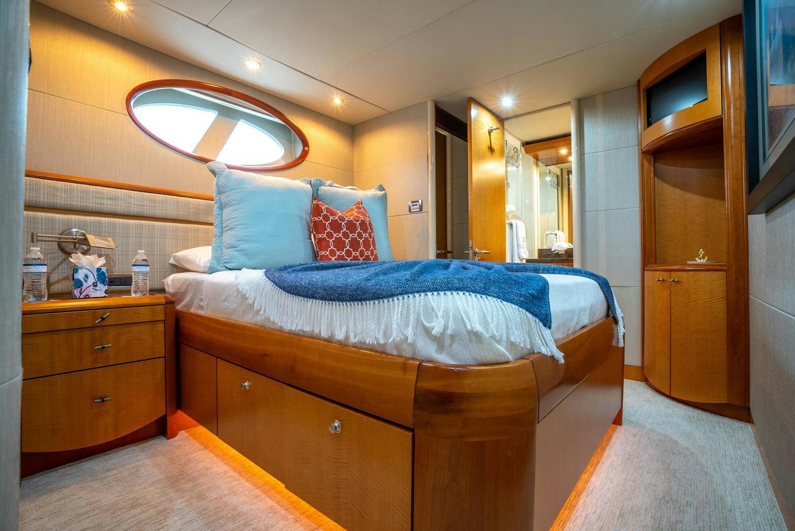 a bedroom with a bed and a dresser aboard STARFIRE Yacht for Sale