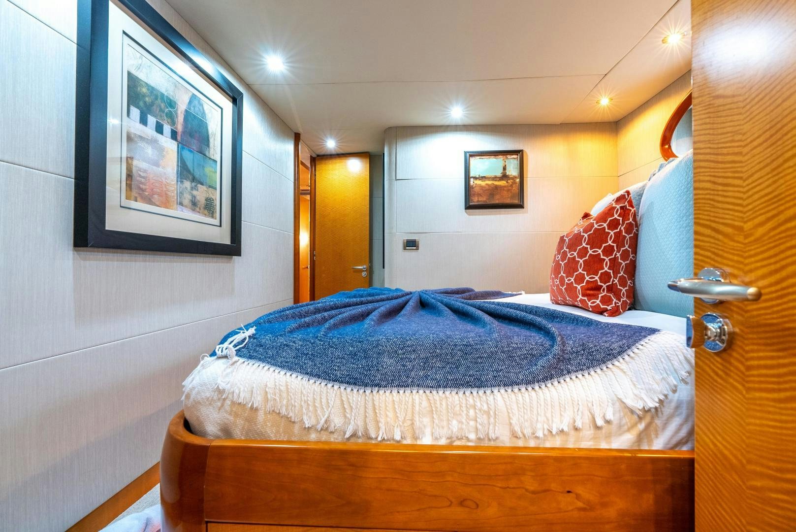 a bed with a blue blanket aboard STARFIRE Yacht for Sale