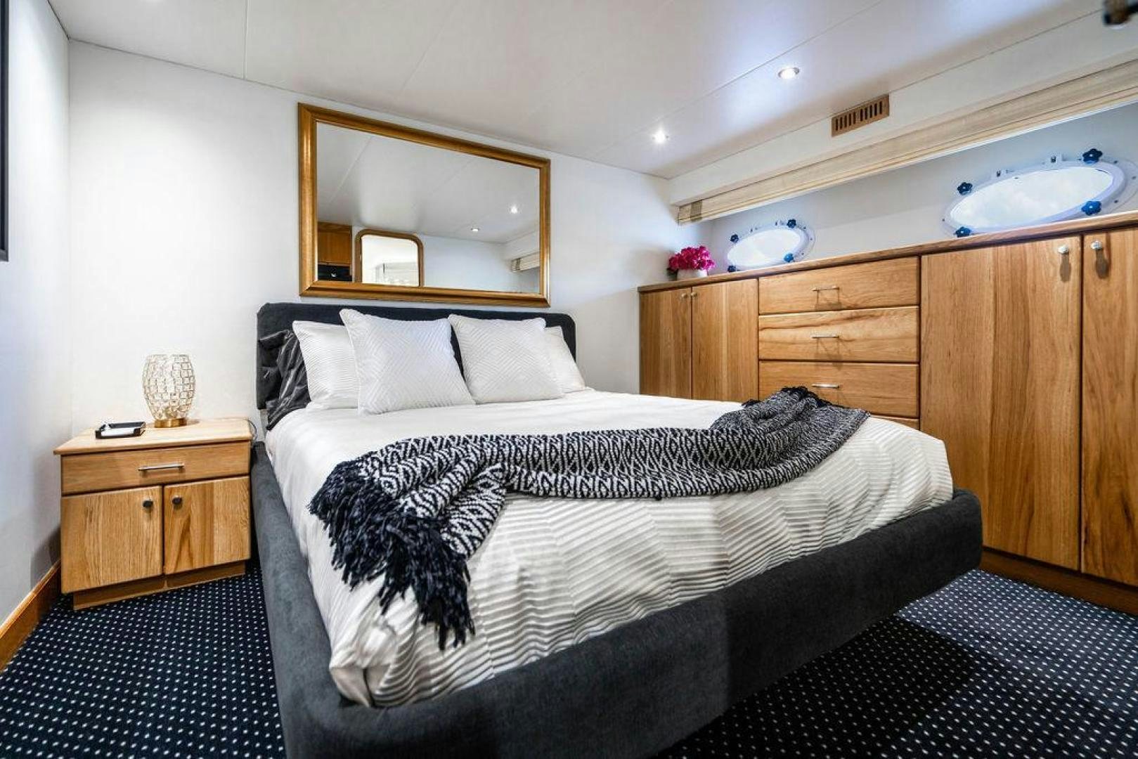 a bedroom with a bed and a dresser aboard THREE BLESSINGS Yacht for Sale