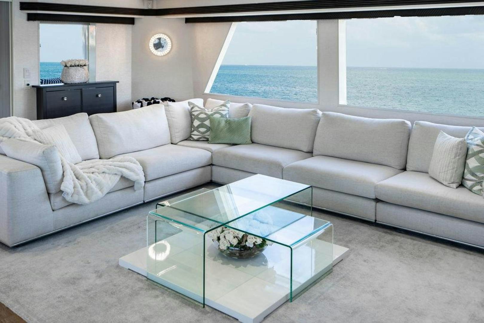 a living room with a large glass coffee table and a large ocean aboard THREE BLESSINGS Yacht for Sale