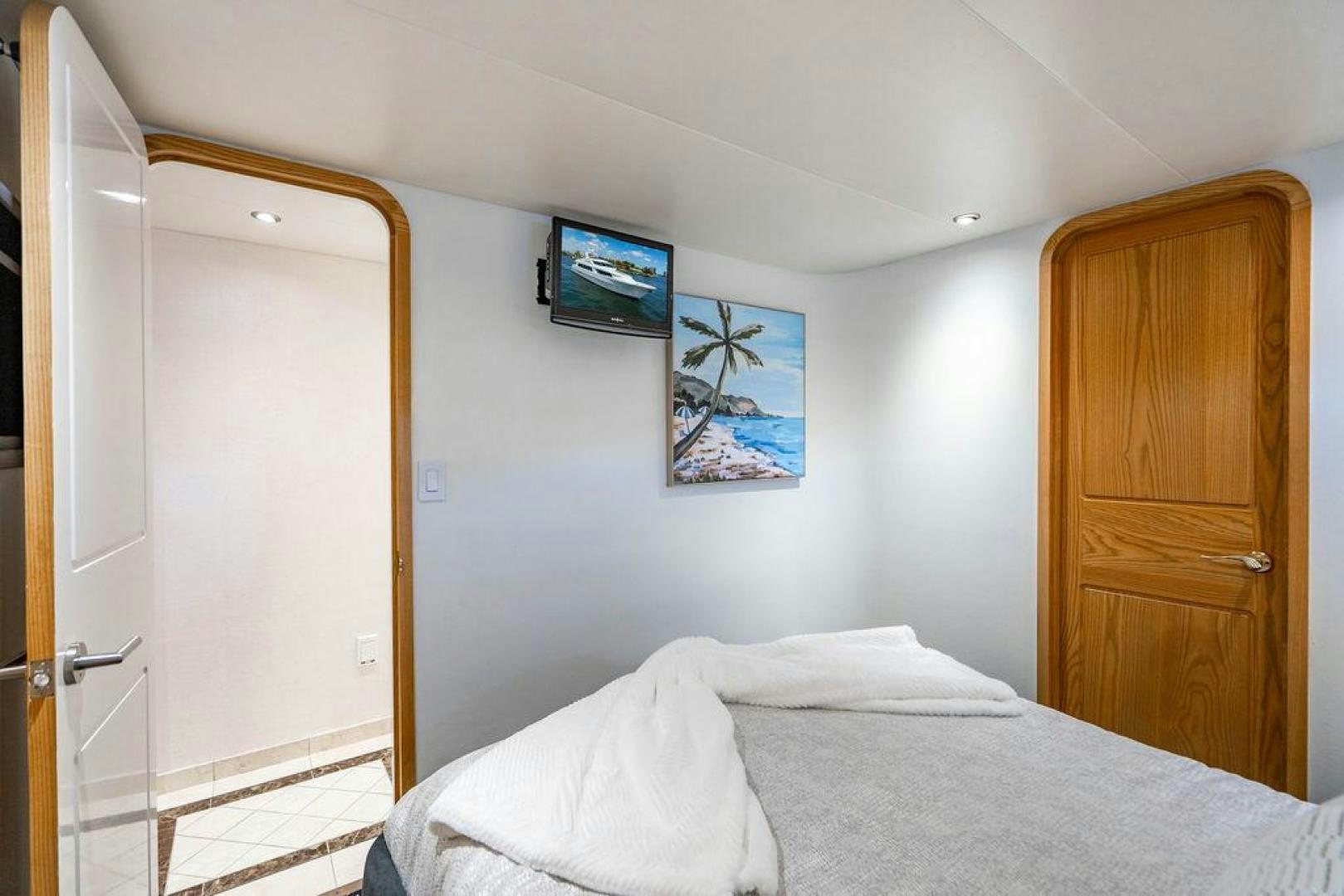 a bedroom with a bed and a television on the wall aboard THREE BLESSINGS Yacht for Sale
