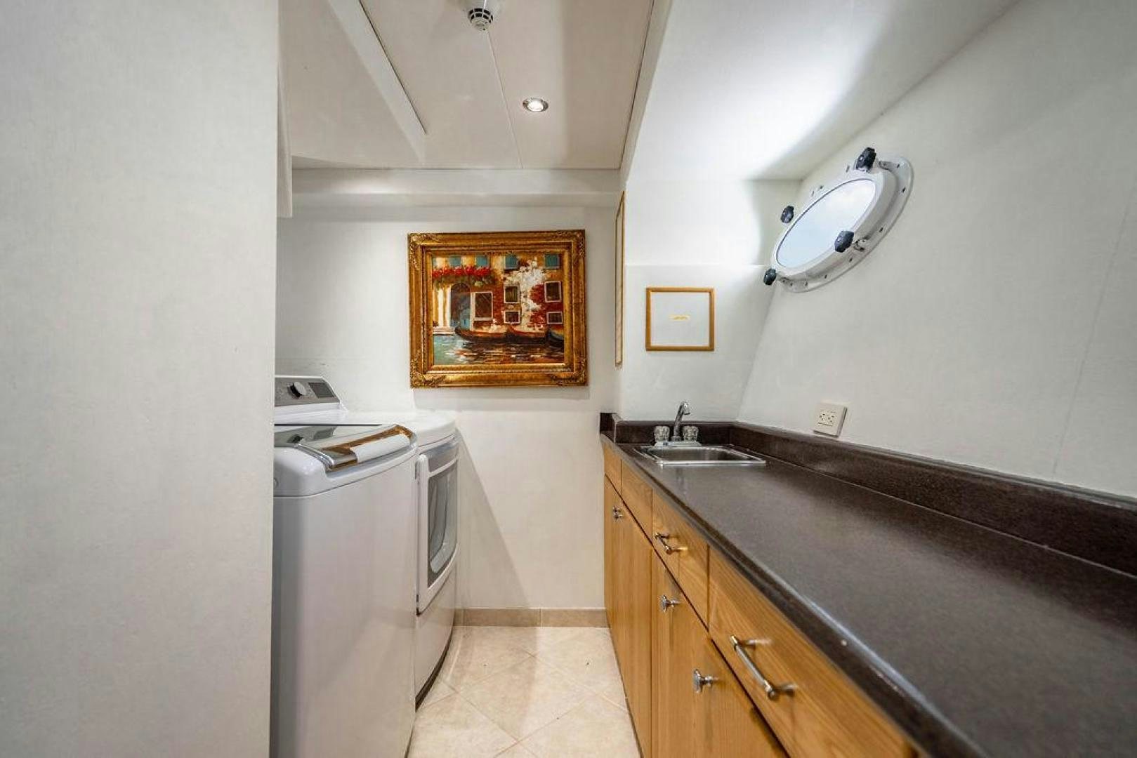 a kitchen with a sink and a painting on the wall aboard THREE BLESSINGS Yacht for Sale
