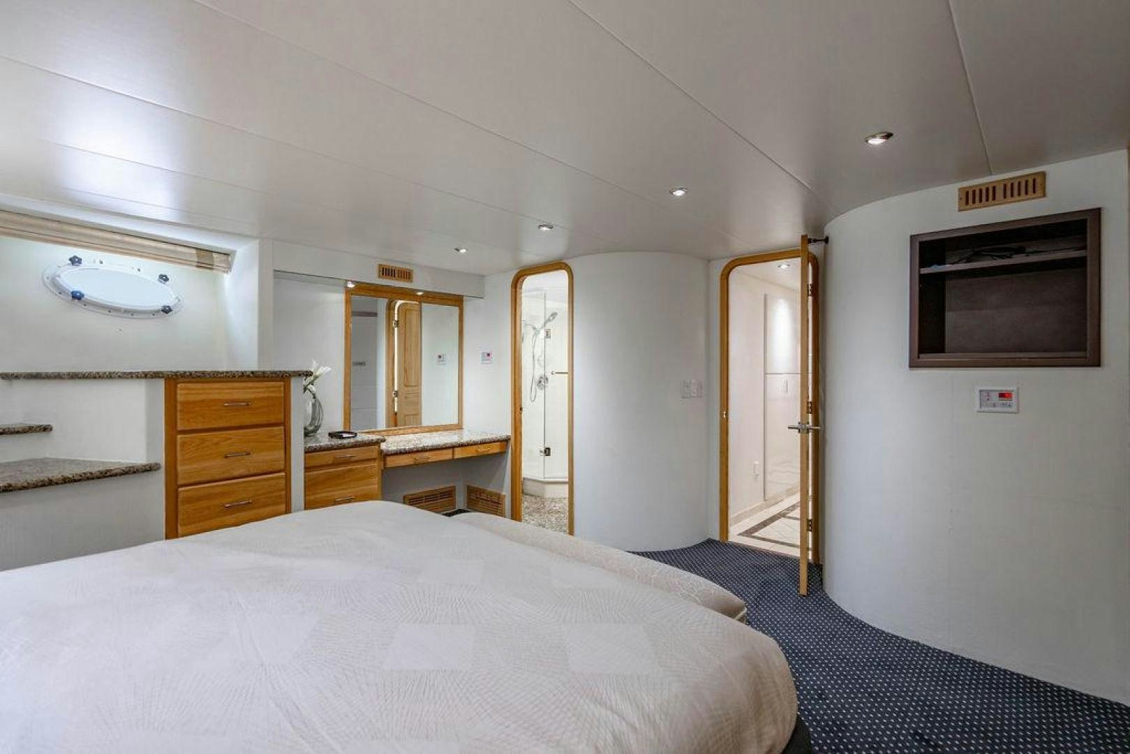 a bedroom with a bed and a television aboard THREE BLESSINGS Yacht for Sale
