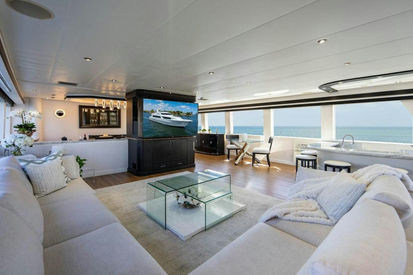 a living room with a large glass table and a large television aboard THREE BLESSINGS Yacht for Sale