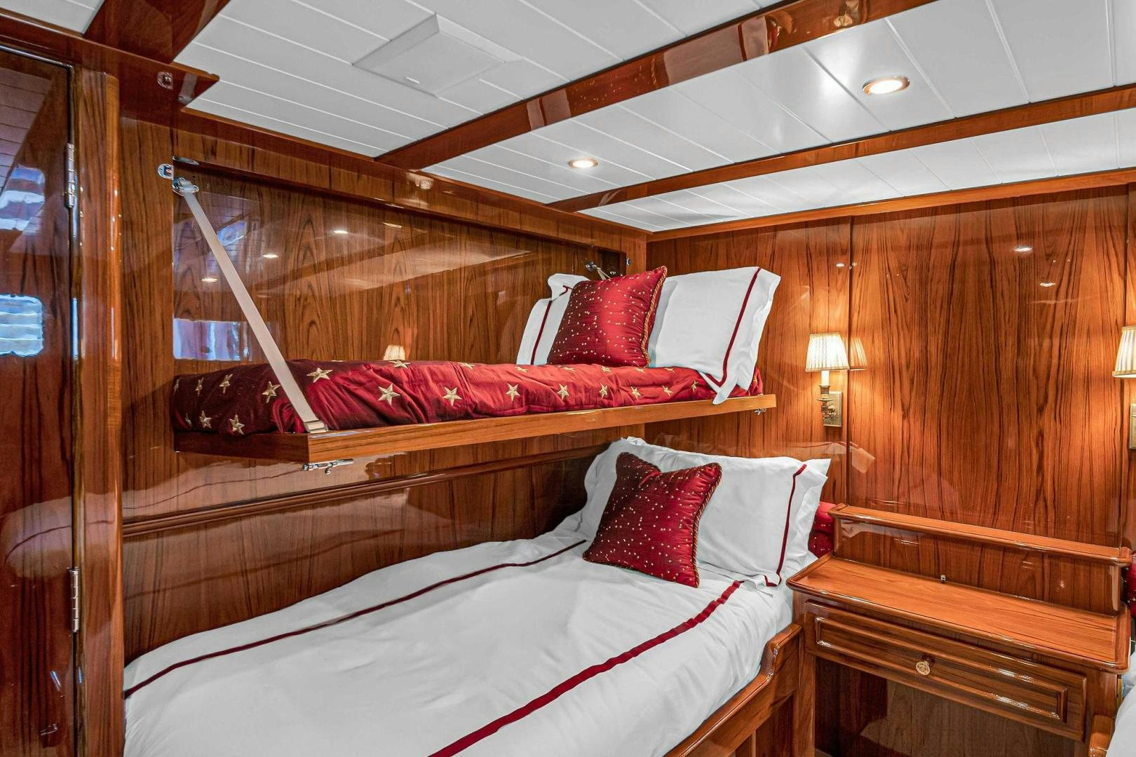a bed with red pillows aboard INEVITABLE Yacht for Sale
