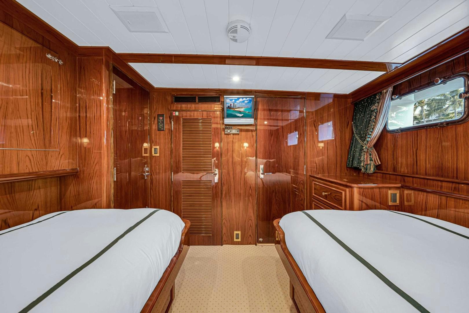 a cabin with a bed and a television aboard INEVITABLE Yacht for Sale