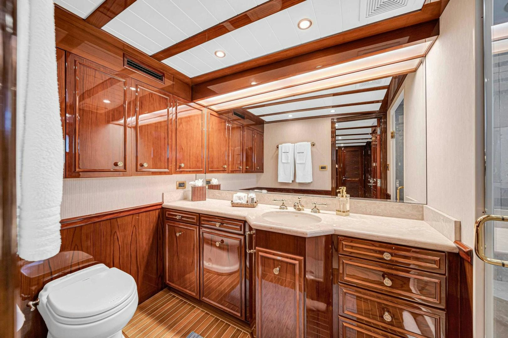 a bathroom with wooden cabinets aboard INEVITABLE Yacht for Sale