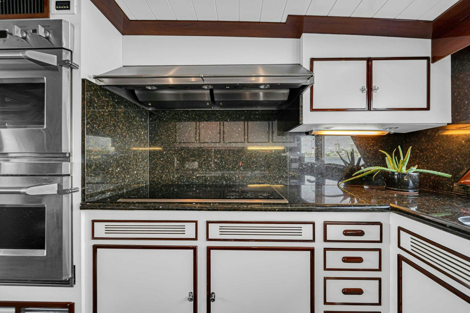 a kitchen with white cabinets aboard INEVITABLE Yacht for Sale