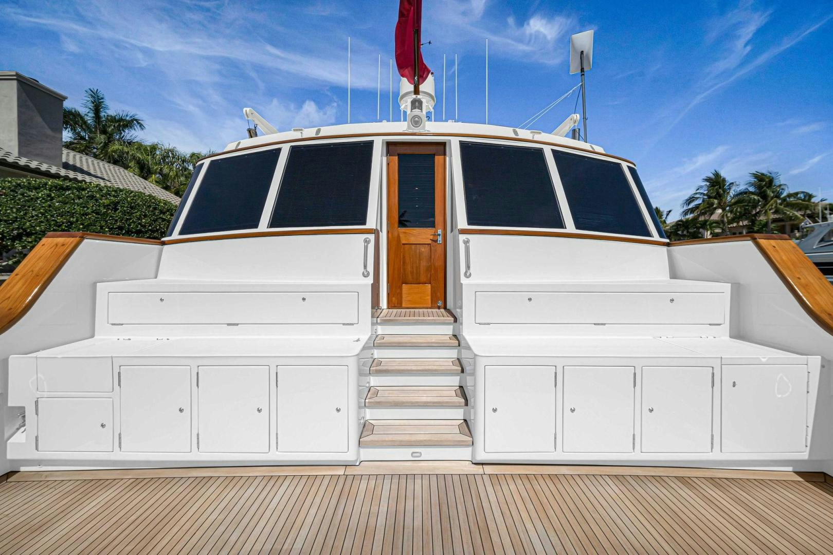 a white building with a black and white roof and a red flag on top of it aboard INEVITABLE Yacht for Sale