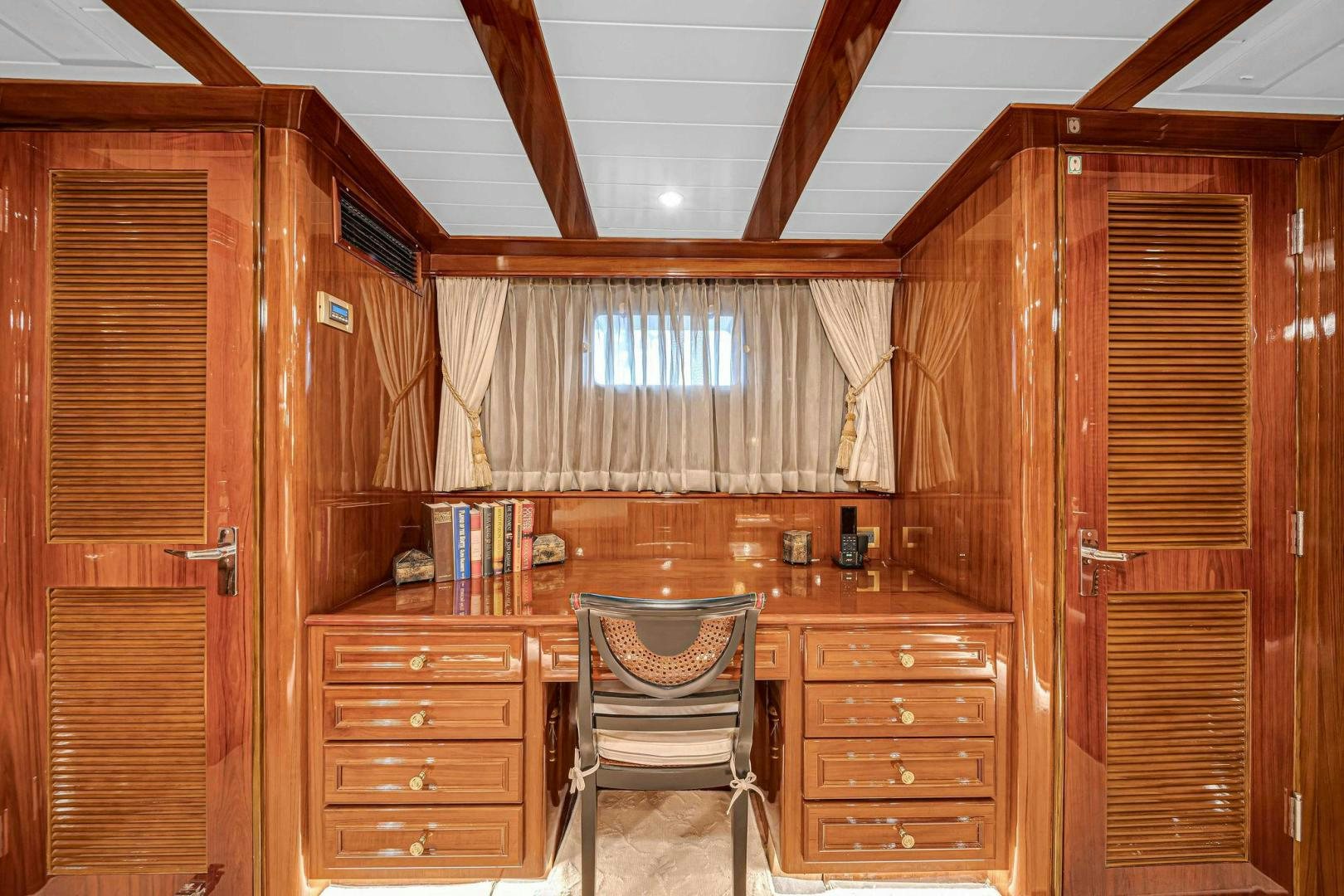 a wooden cabin with a chair and a desk aboard INEVITABLE Yacht for Sale