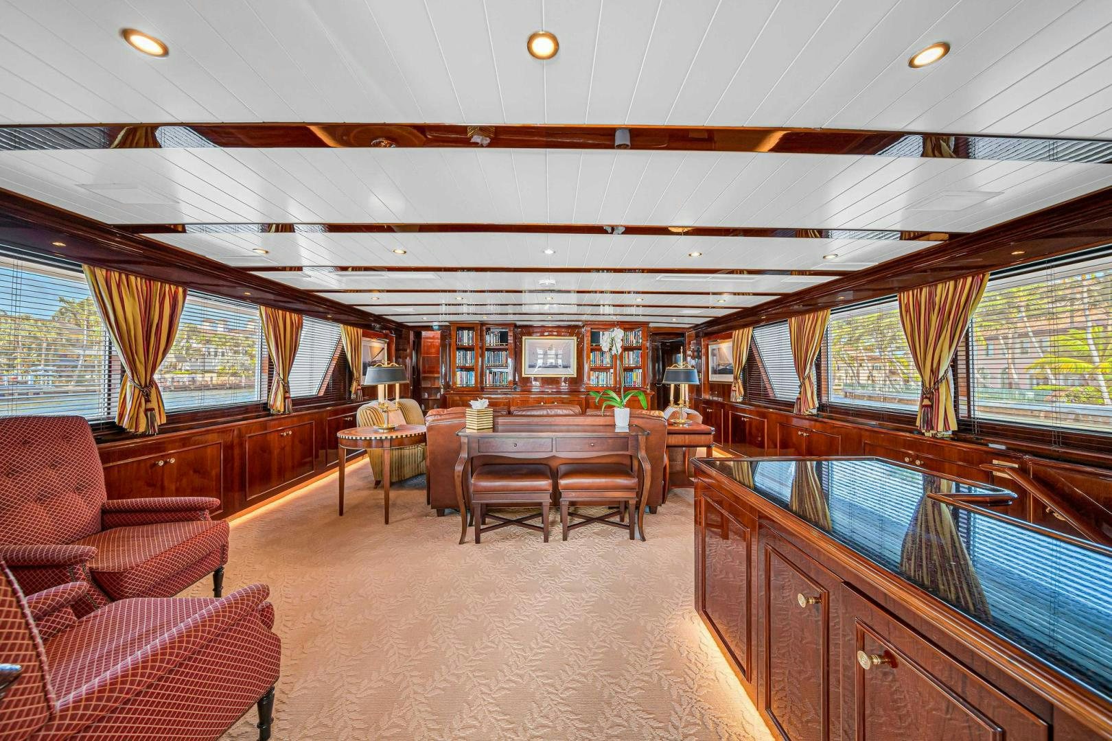 a large living room with a wood table and chairs aboard INEVITABLE Yacht for Sale