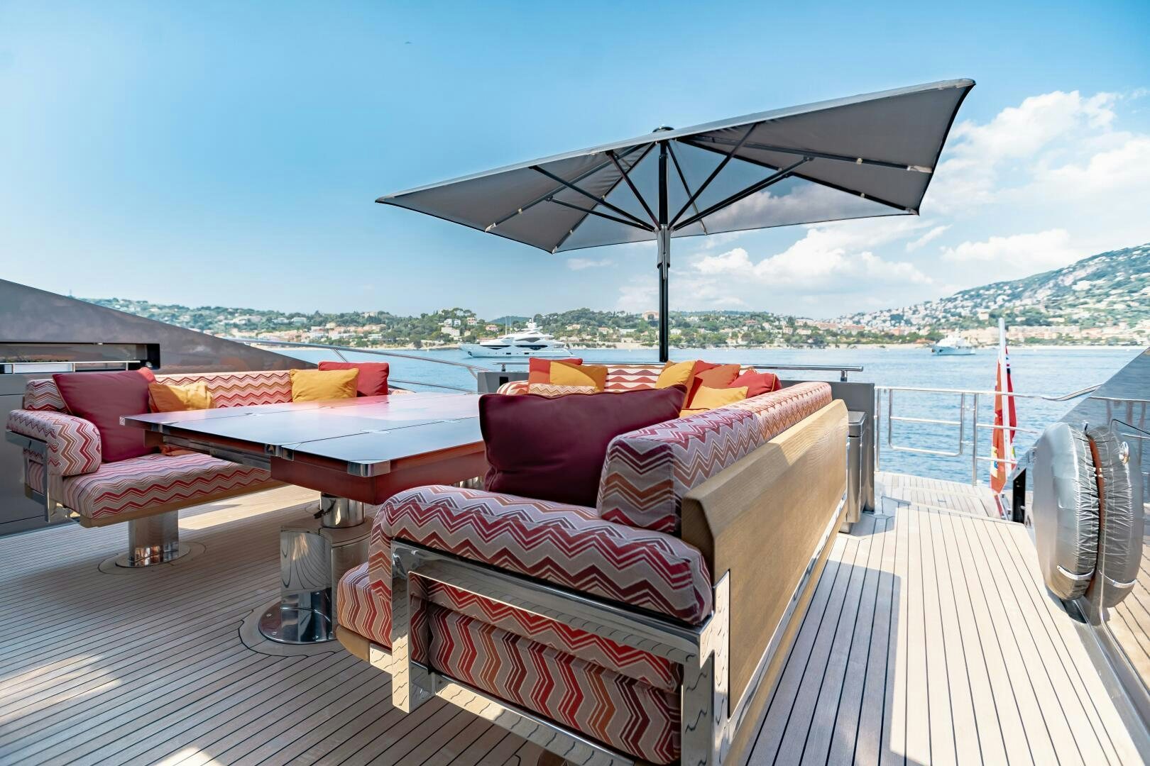 a boat on a deck with a large umbrella over it aboard KJOS Yacht for Sale