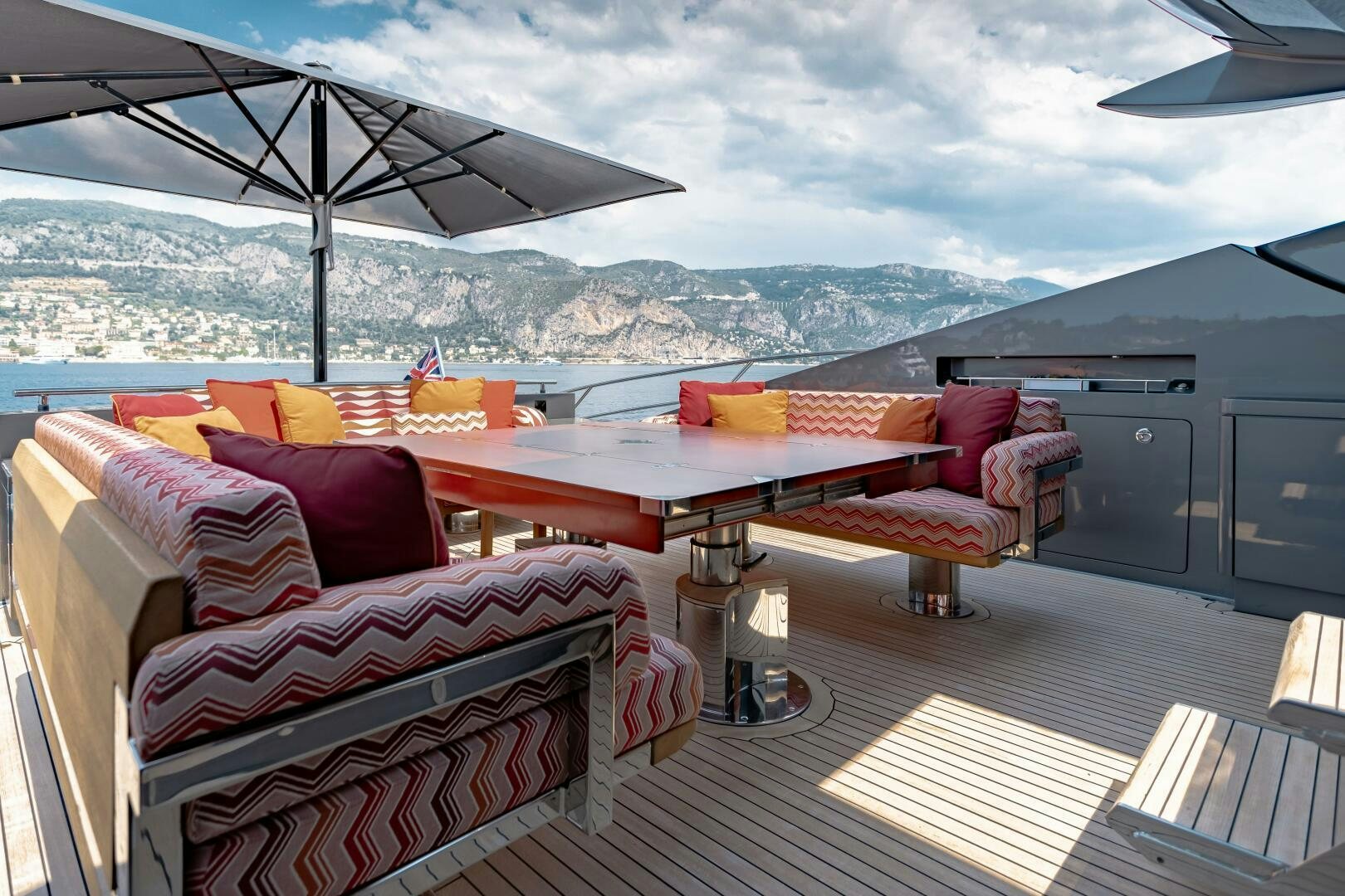 a deck with a table and chairs aboard KJOS Yacht for Sale