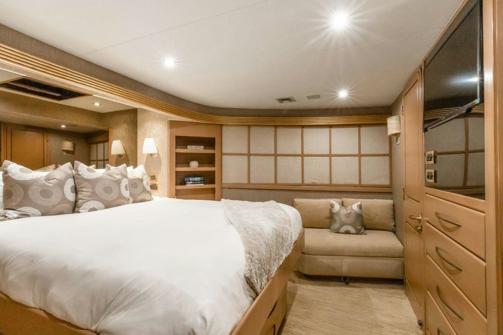 a bedroom with a bed and a television aboard CHECKERED PAST Yacht for Sale