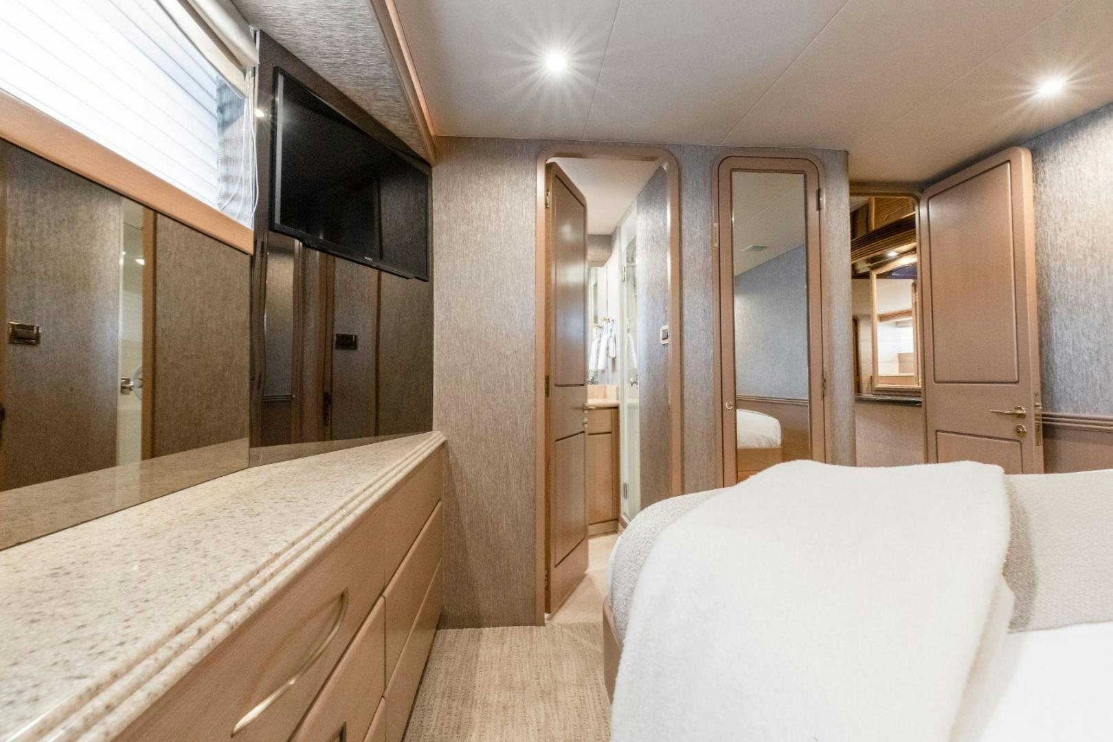 a bedroom with a bed and a large mirror aboard CHECKERED PAST Yacht for Sale