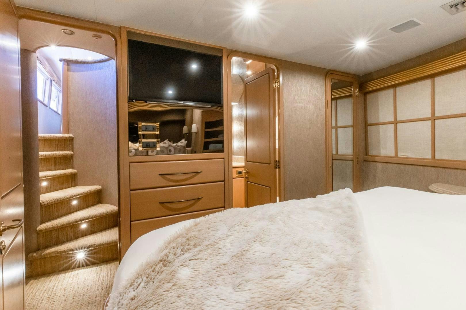 a bedroom with a bed and a closet aboard CHECKERED PAST Yacht for Sale