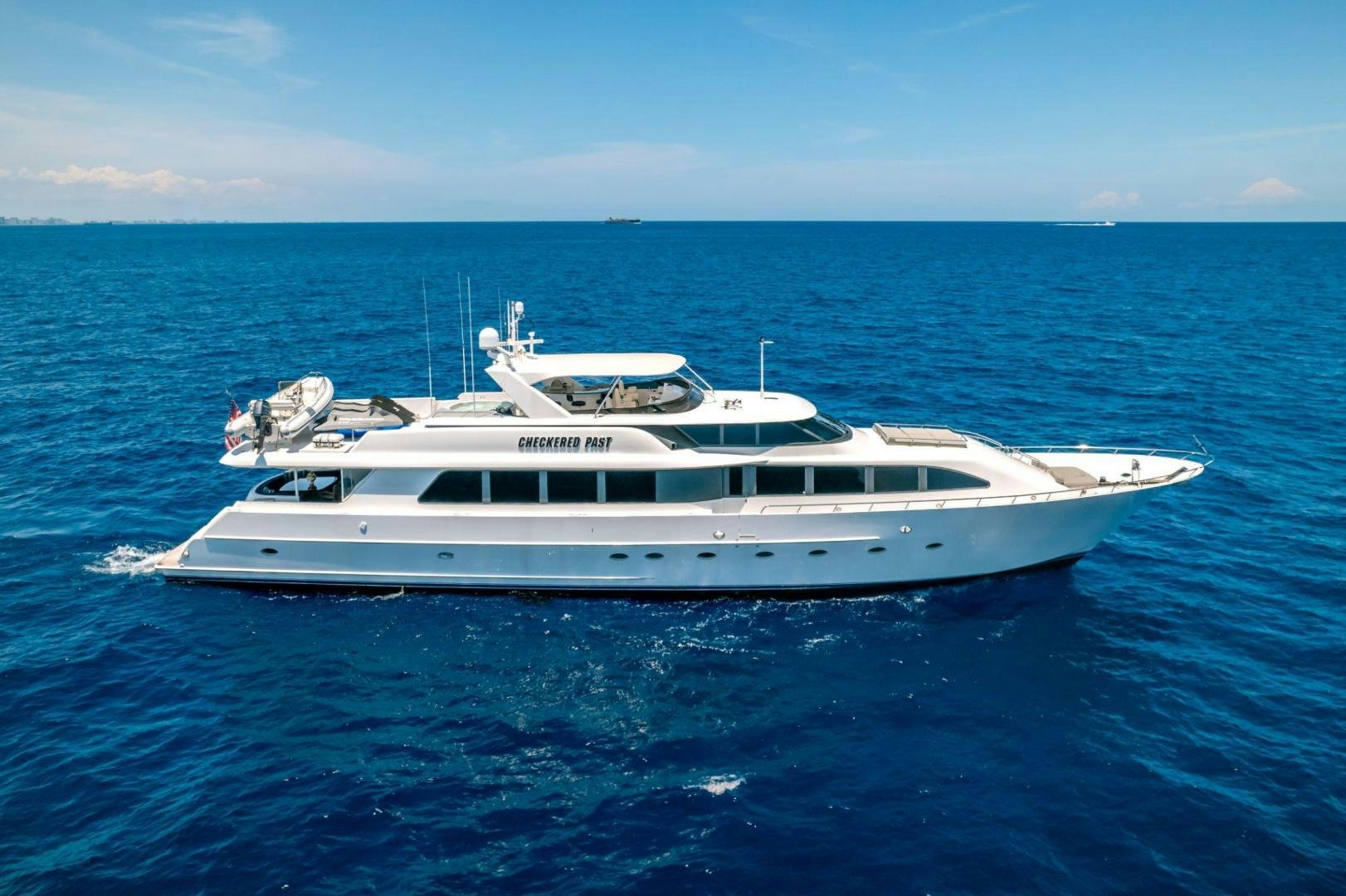 a white boat in the water aboard CHECKERED PAST Yacht for Sale
