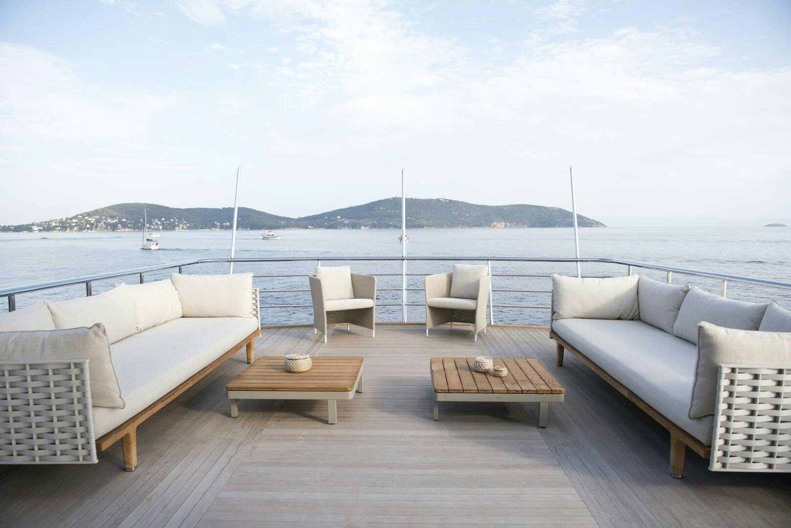 a group of white couches on a deck overlooking a body of water aboard PICCOLO Yacht for Sale