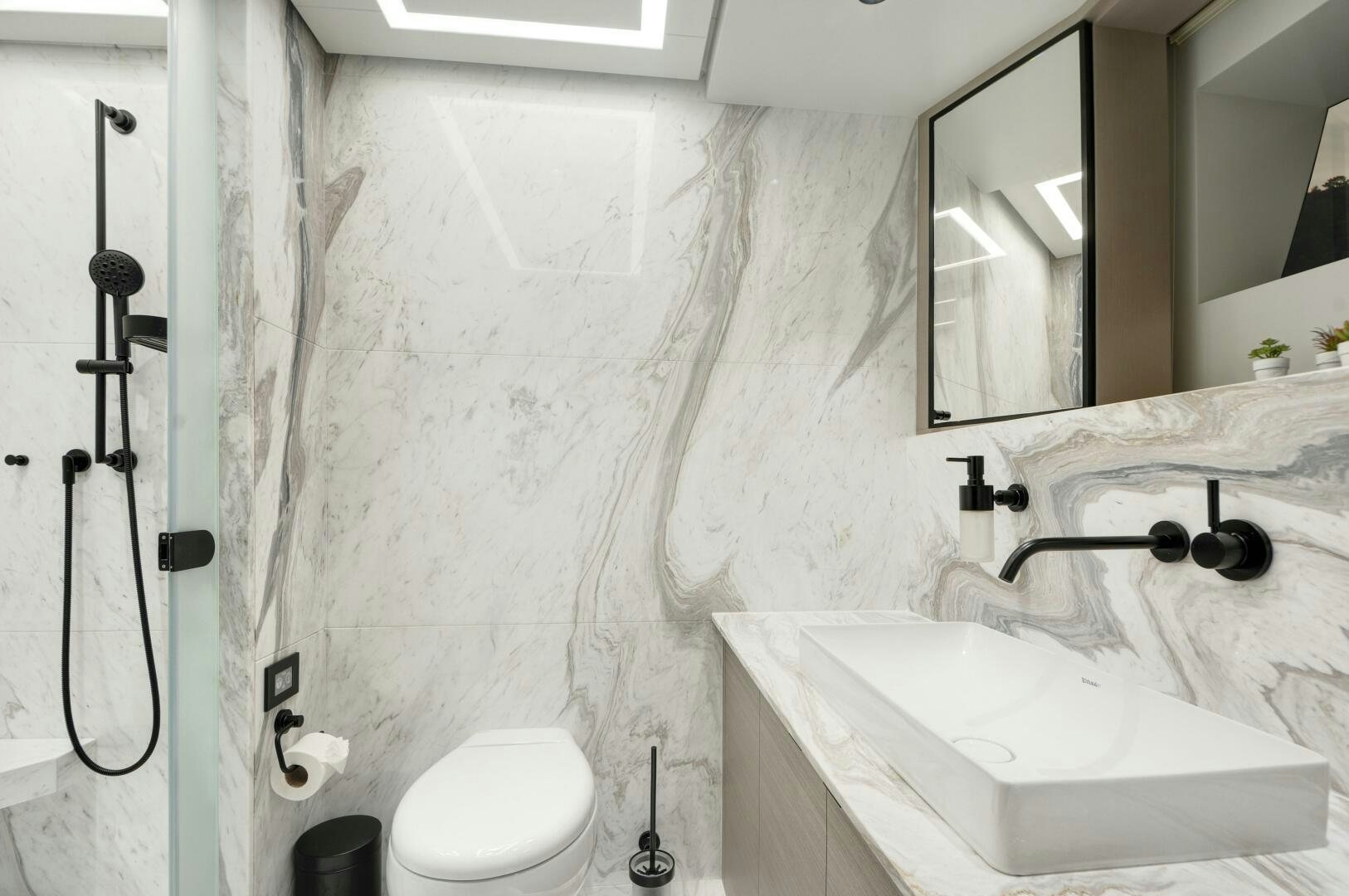 a bathroom with a sink toilet and mirror aboard PICCOLO Yacht for Sale