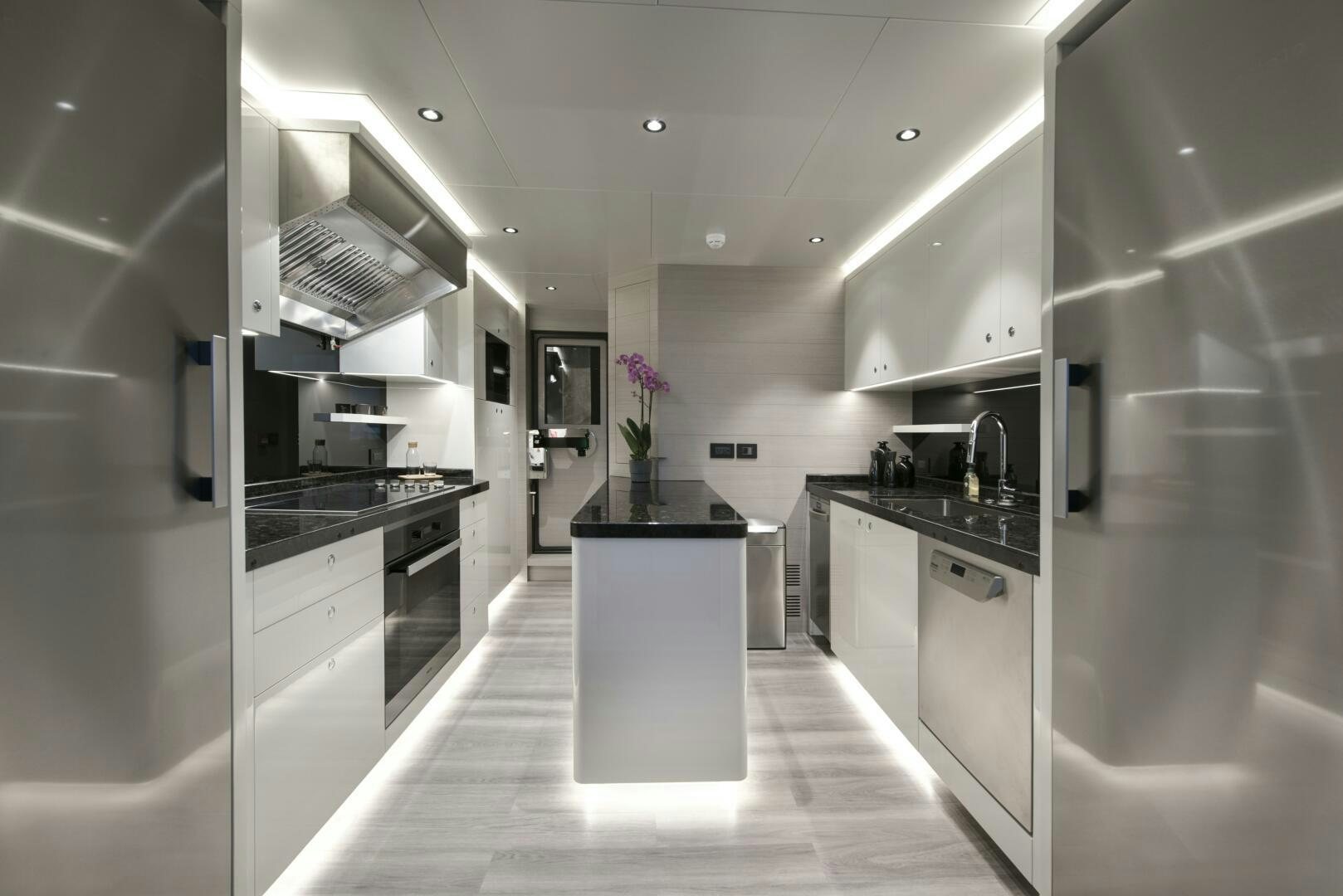 a kitchen with white cabinets aboard PICCOLO Yacht for Sale