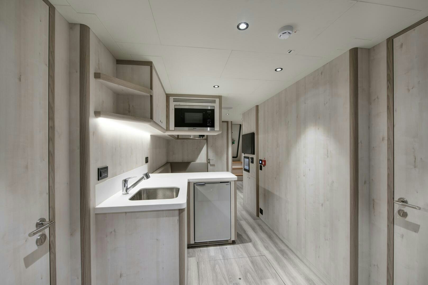 a kitchen with white cabinets aboard PICCOLO Yacht for Sale