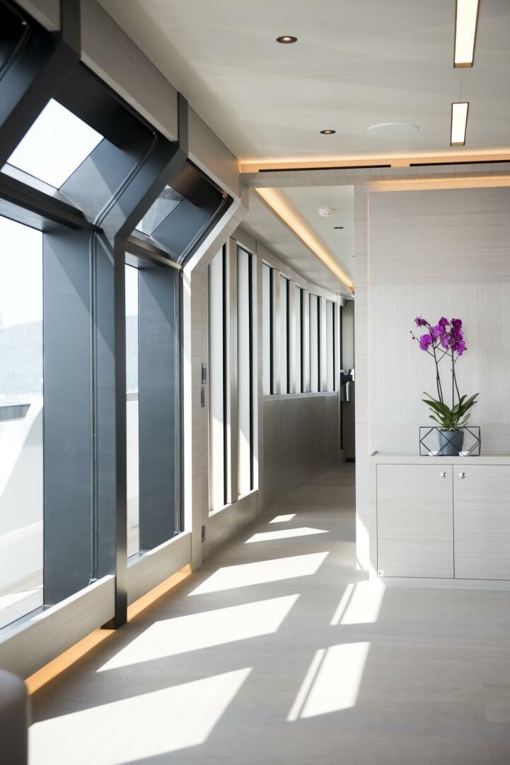 a hallway with a black door and a vase of flowers aboard PICCOLO Yacht for Sale