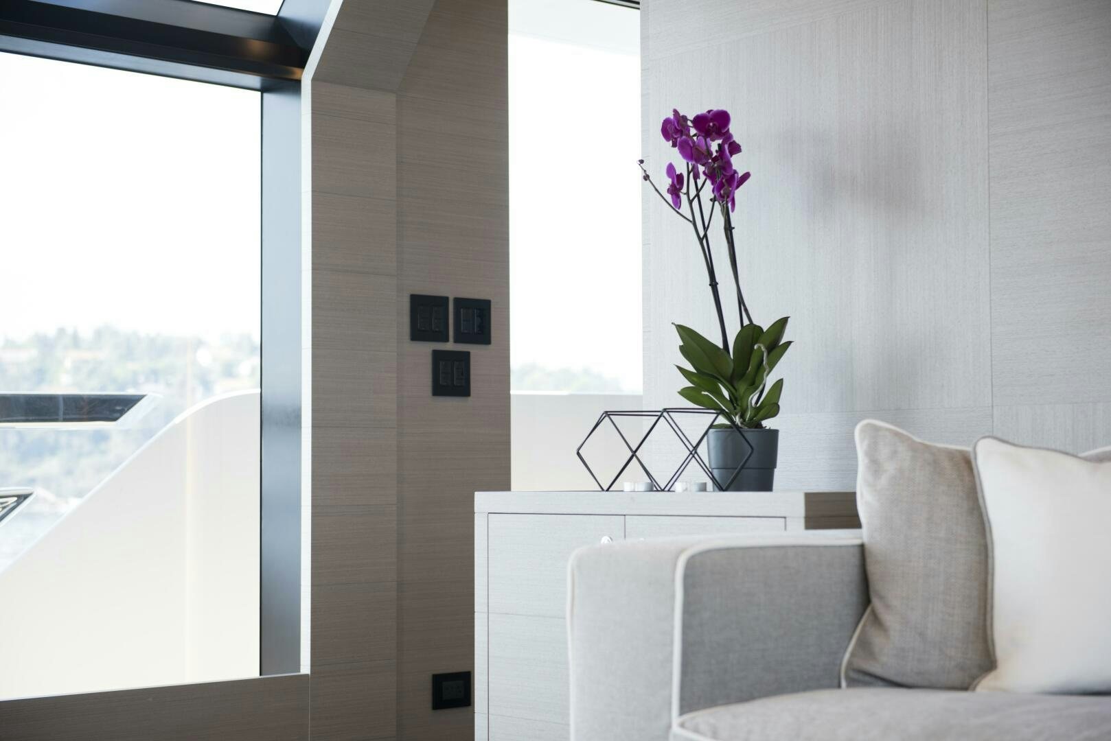 a plant in a pot on a table in a room with a window aboard PICCOLO Yacht for Sale
