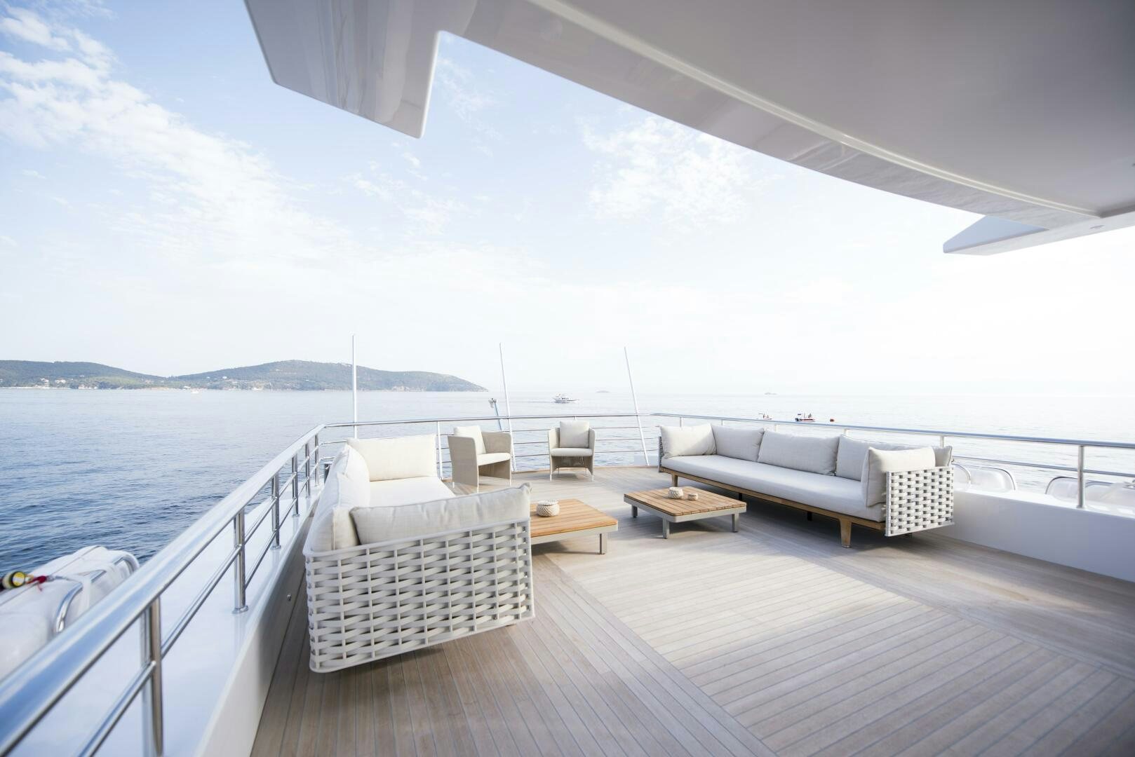 a deck with chairs and a body of water aboard PICCOLO Yacht for Sale