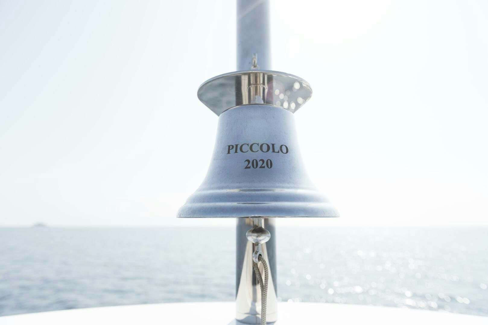 a metal bell with a logo on it aboard PICCOLO Yacht for Sale