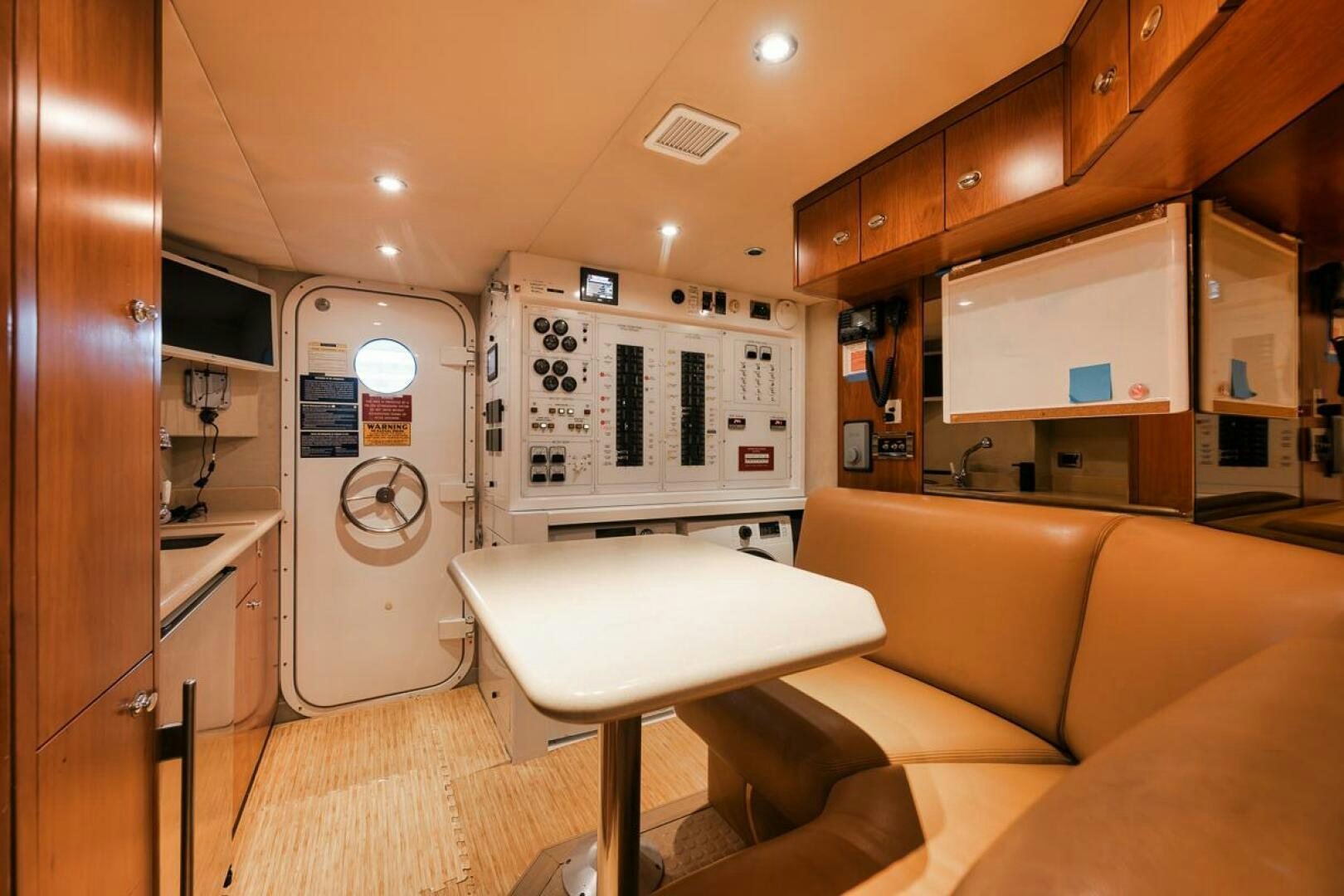 a small living room with a small kitchen and a small table aboard NATURAL 9 X KALEEN Yacht for Sale
