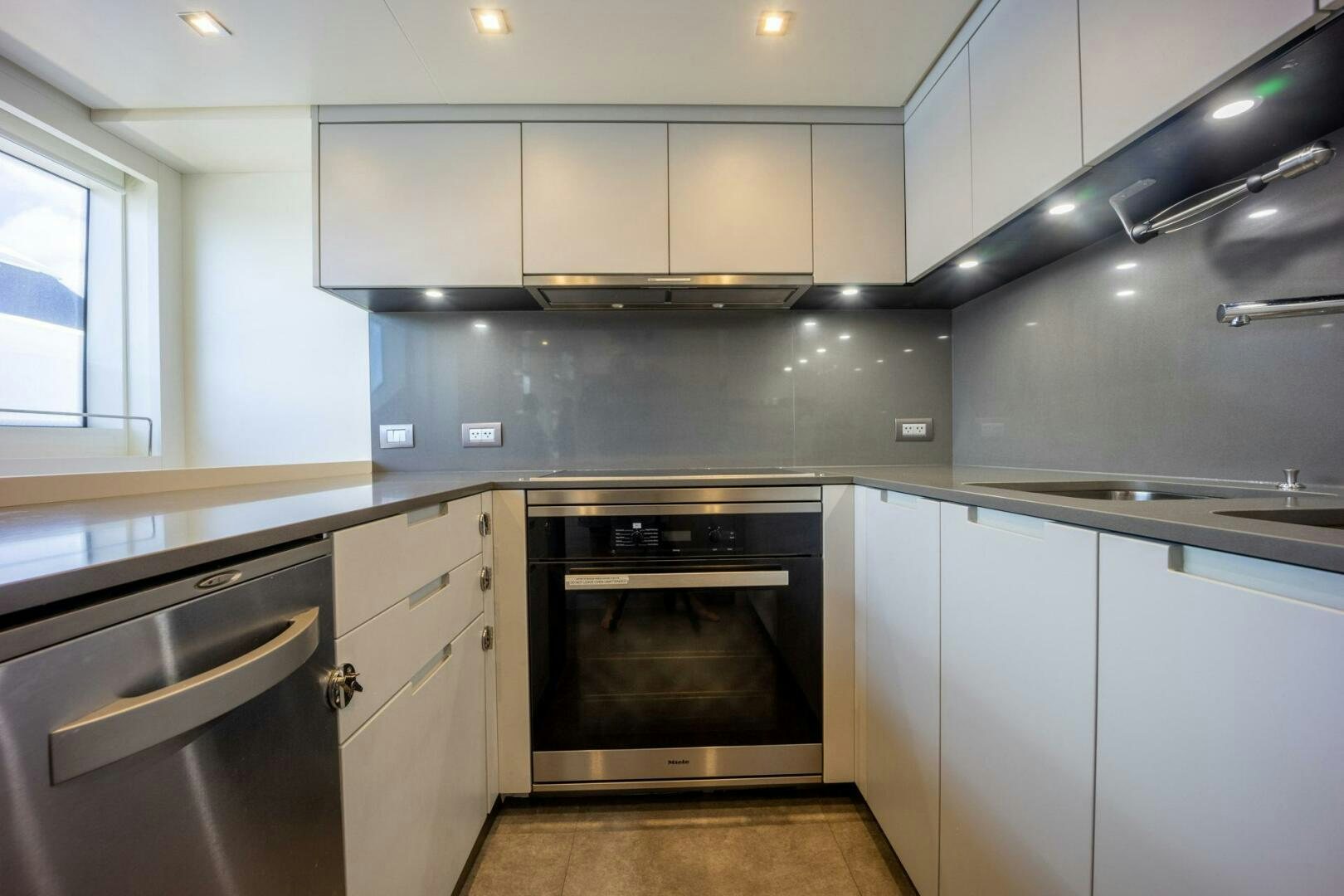 a kitchen with white cabinets aboard PHOENIX Yacht for Sale