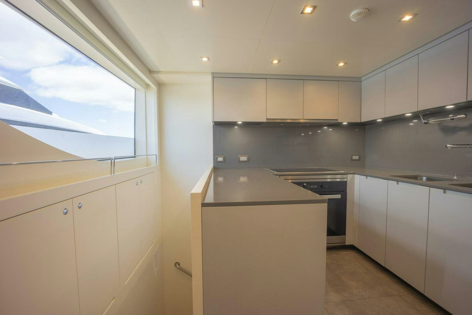 a kitchen with white cabinets aboard PHOENIX Yacht for Sale