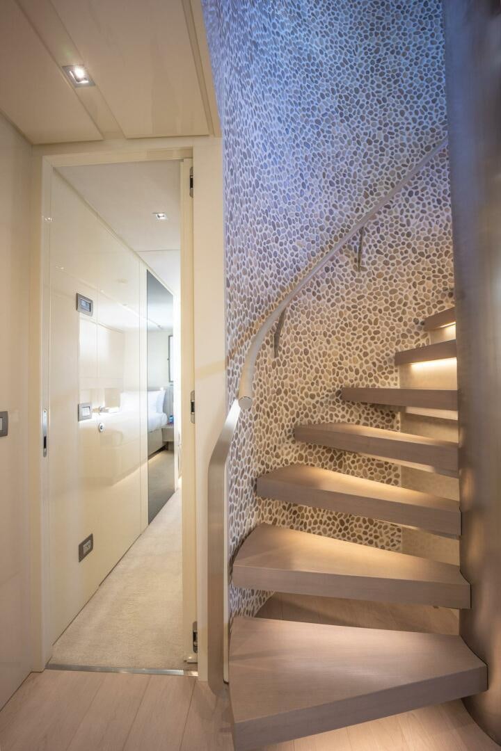 a staircase with a blue wall aboard PHOENIX Yacht for Sale