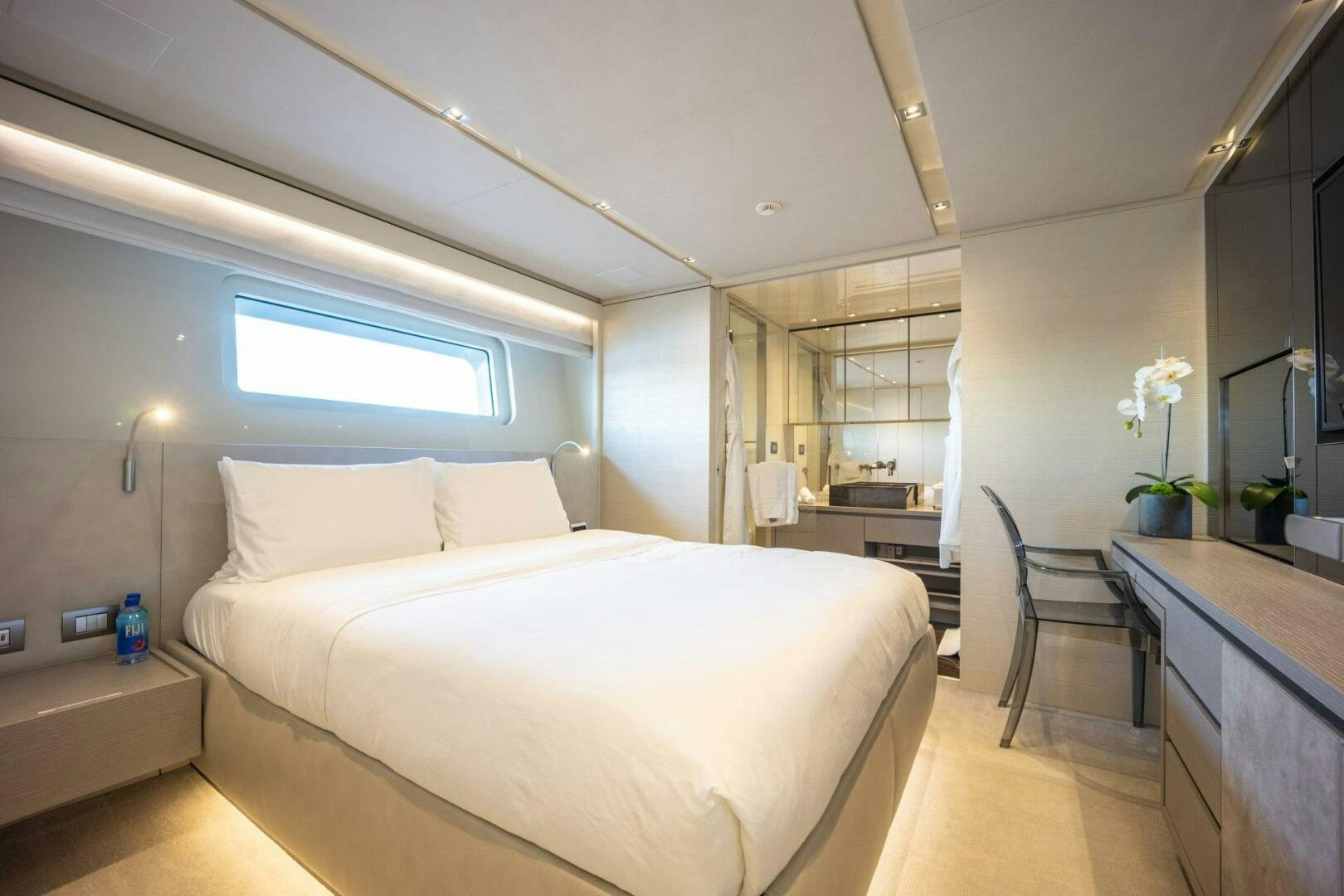 a bedroom with a bed and a chair aboard PHOENIX Yacht for Sale