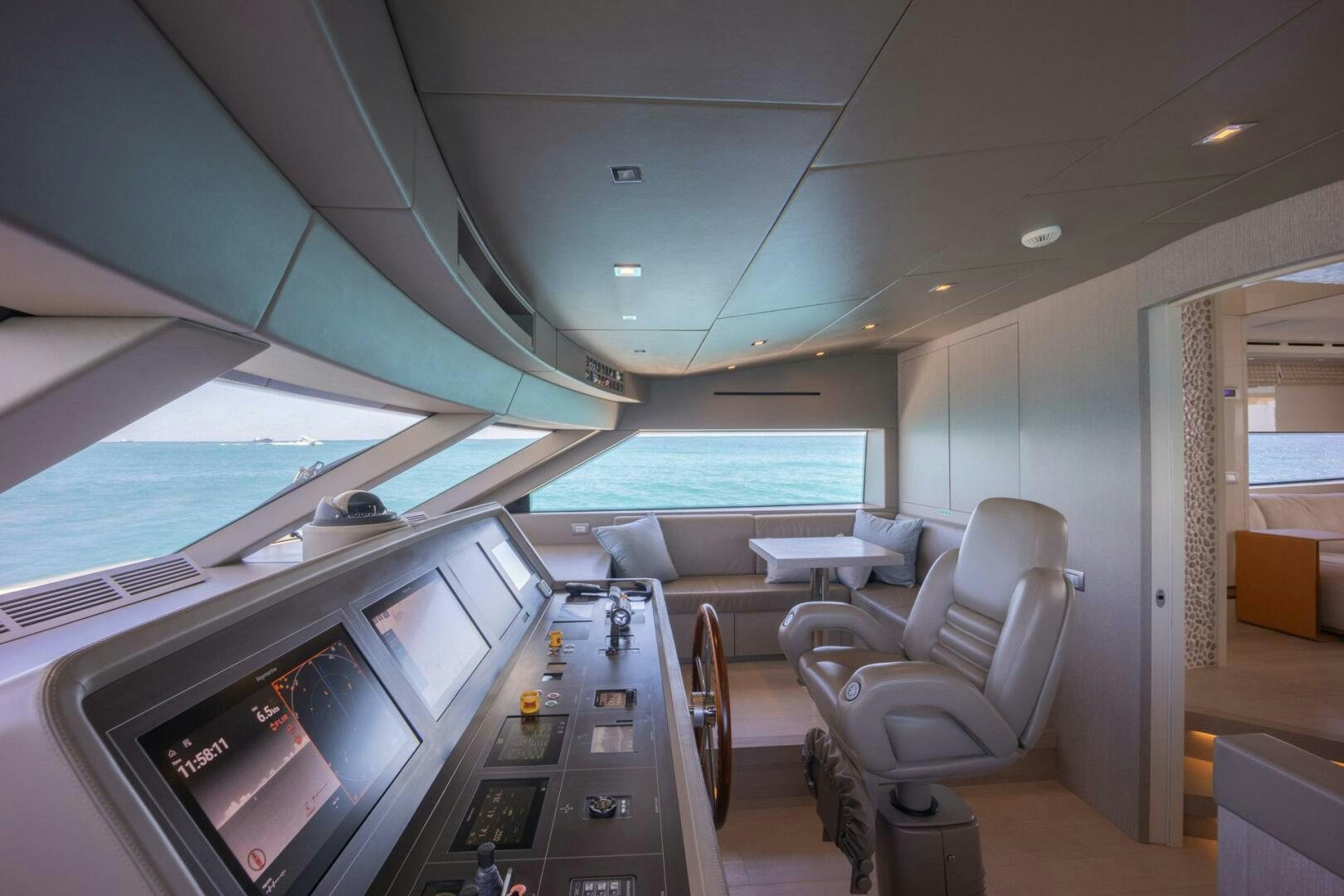 inside of a vehicle with a large screen and a table and chairs aboard PHOENIX Yacht for Sale