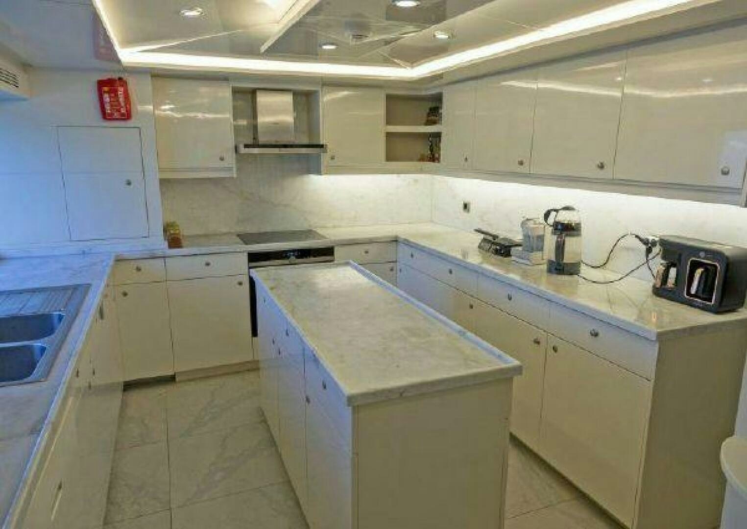 a kitchen with white cabinets aboard VETRO Yacht for Sale