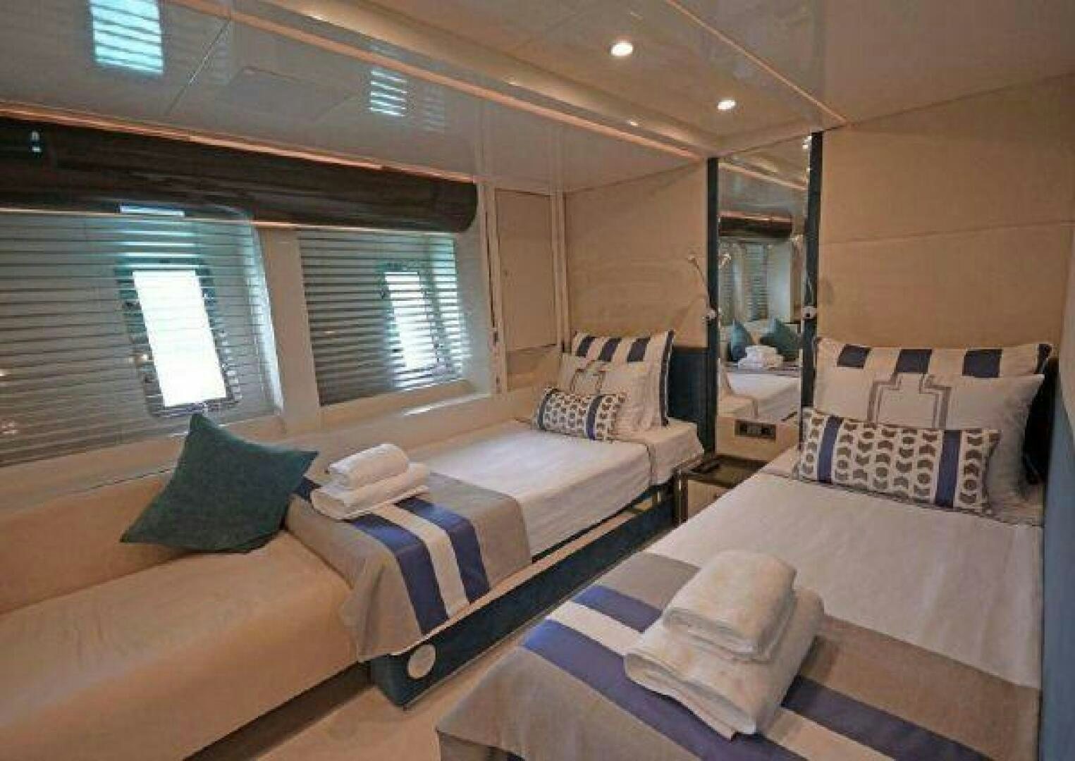 a room with beds and a mirror aboard VETRO Yacht for Sale
