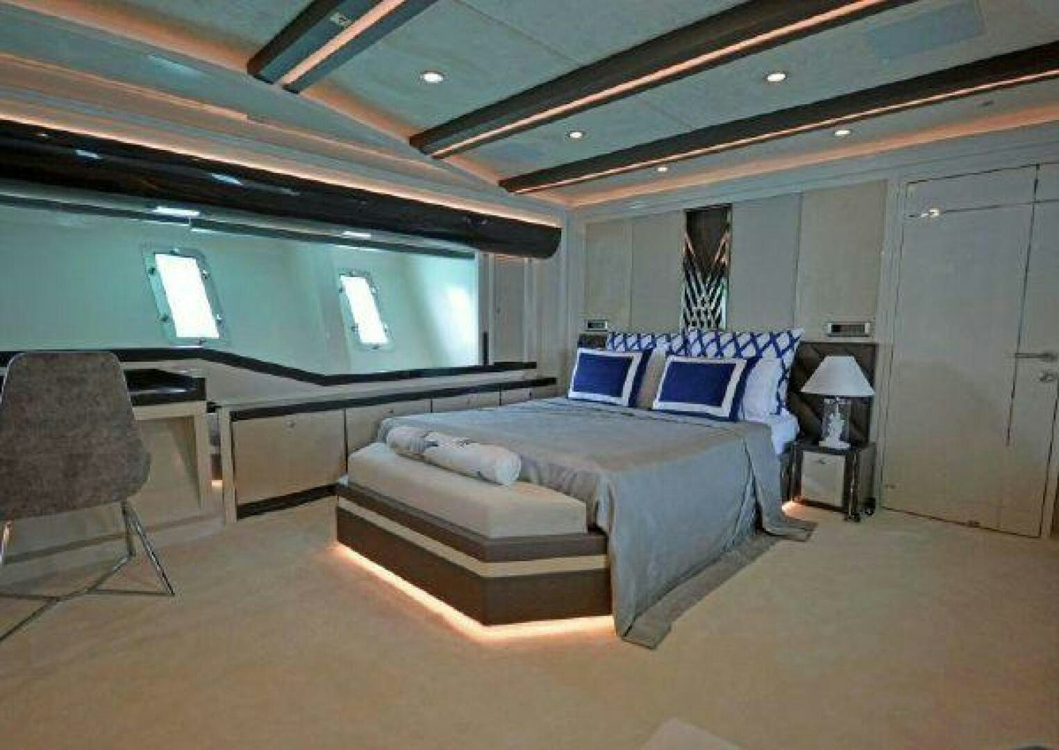 a bedroom with a bed and a desk aboard VETRO Yacht for Sale