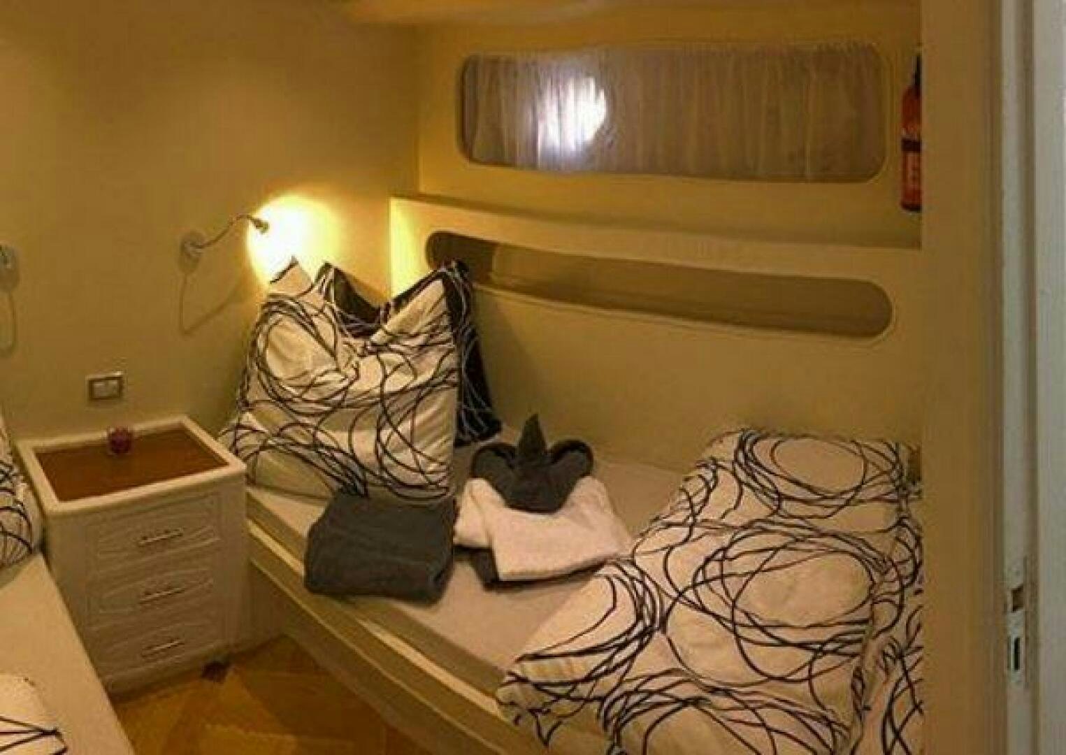 a room with a bed and a dresser aboard RED SEA QUEEN Yacht for Sale