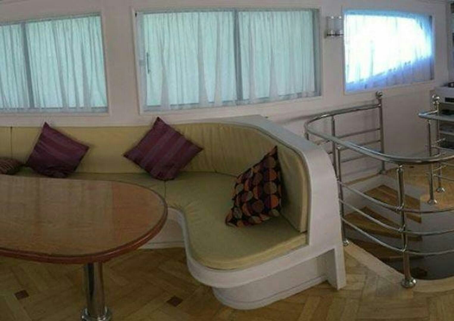 a bed with a table and chairs aboard RED SEA QUEEN Yacht for Sale